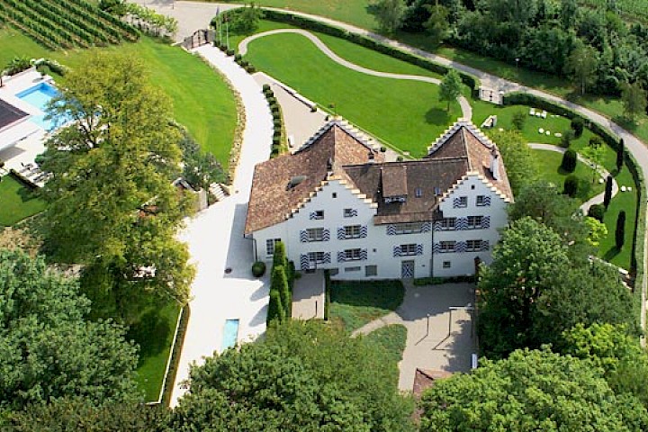 Luftaufnahme - Nordfassade, Pool und Gärtnerhaus (Walmdach am unteren Ende des Bildes, rechts der Mitte).