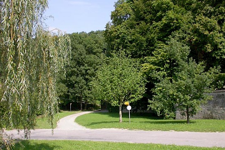 Parkanlage mit Oekonomiegebäude im Hintergrund, ausserhalb der Schlossmauern.